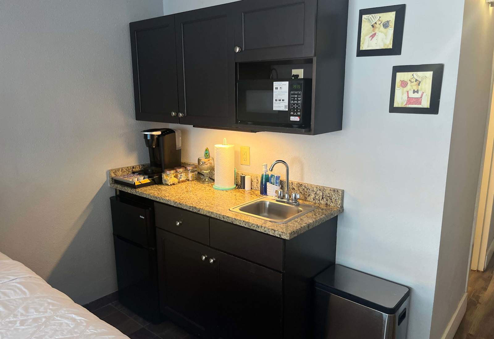 Compact kitchenette station equipped with a microwave, coffee maker, sink, and mini fridge