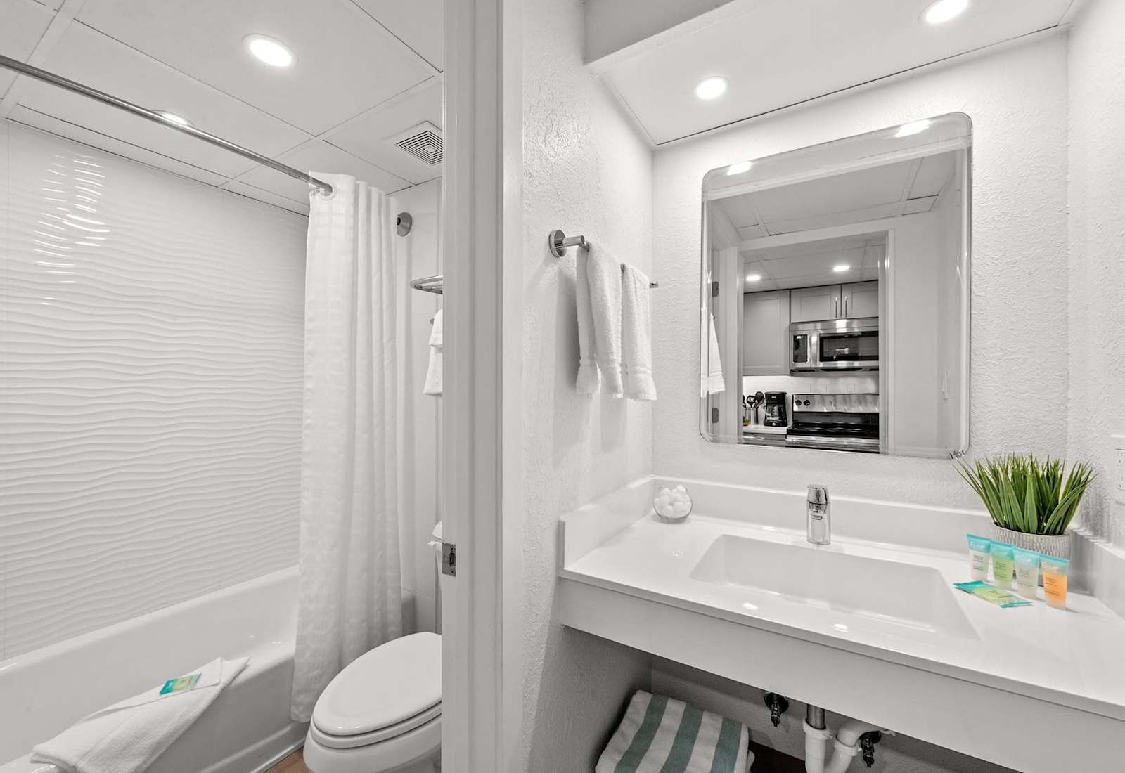 Clean and modern bathroom with a shower/tub combo and granite countertop vanity. 
