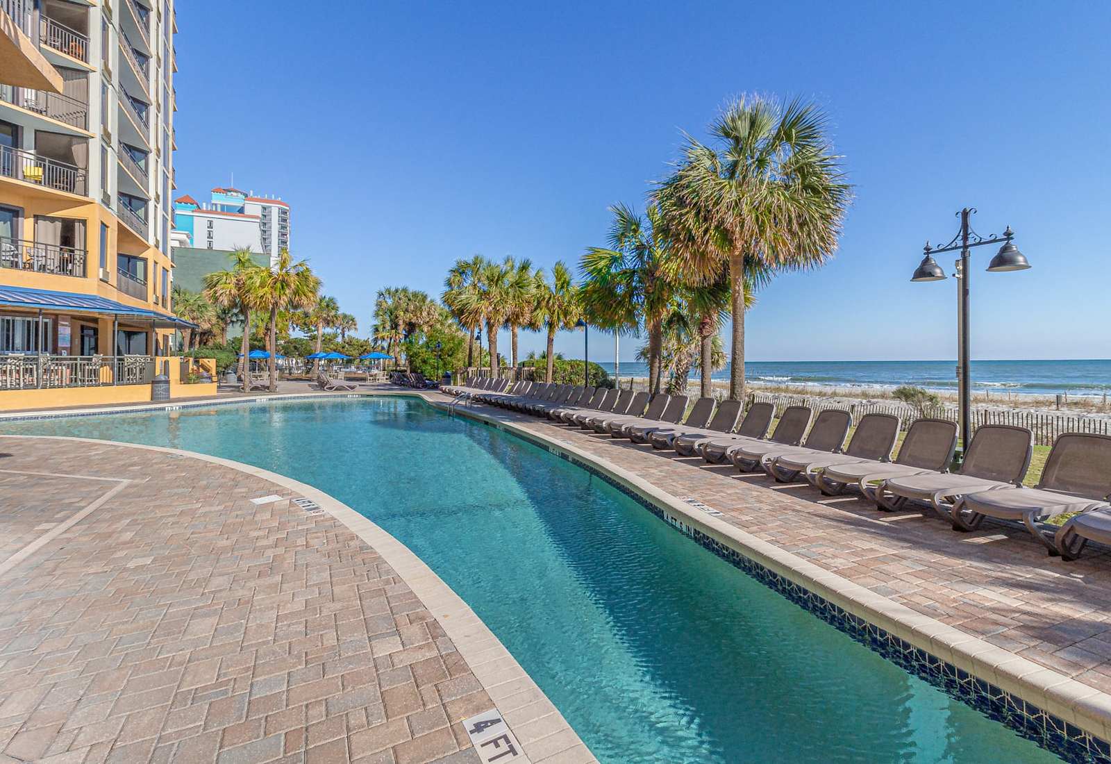 The outdoor pool is expansive and inviting, perfect for a refreshing swim or lounging poolside. Overlooking the beach, it offers plenty of space to relax, unwind, and enjoy the sun with stunning views of the Atlantic just steps away!