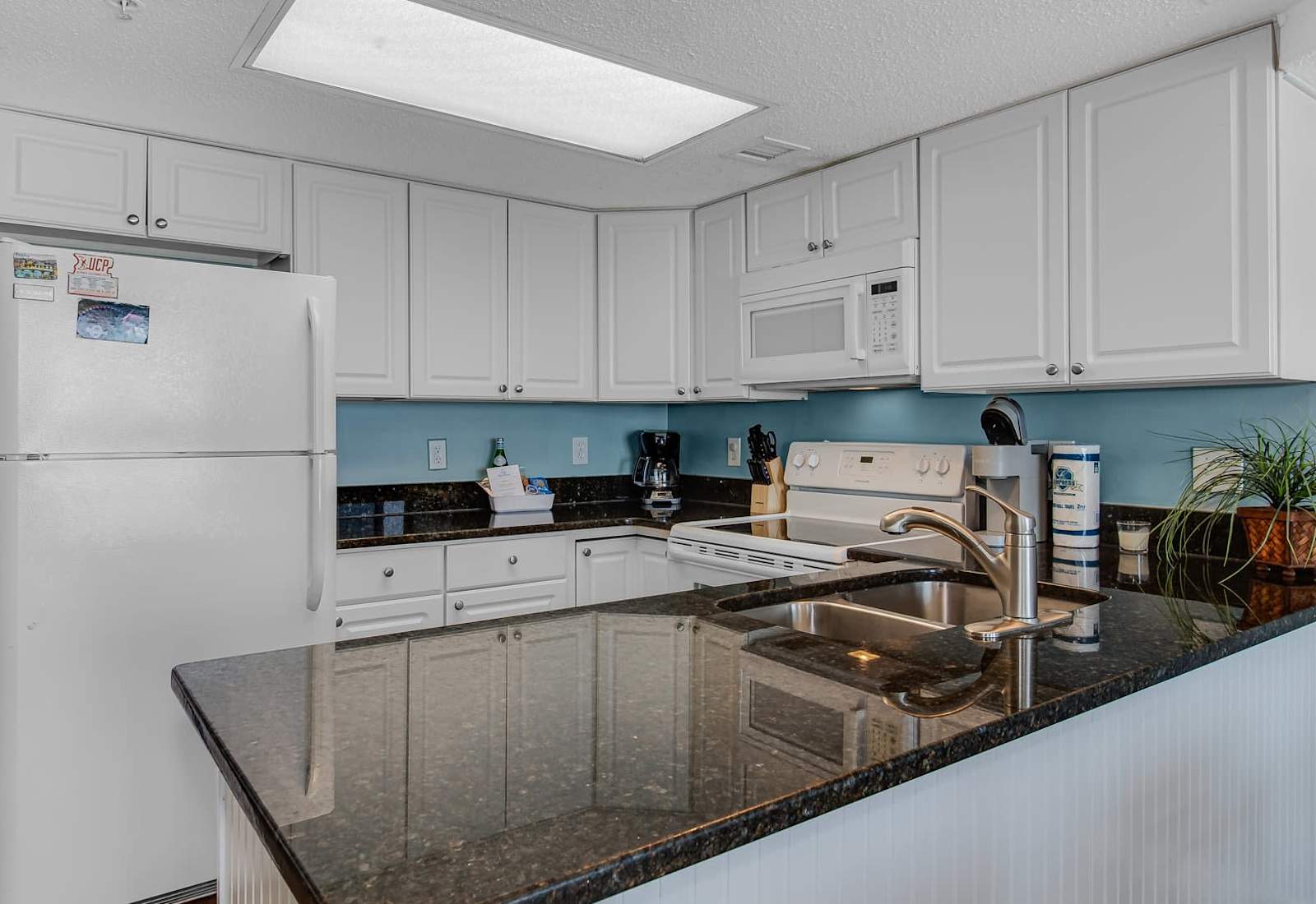 Prepare meals or sip your coffee in this stylish, fully equipped kitchen with modern appliances and ample counter space.