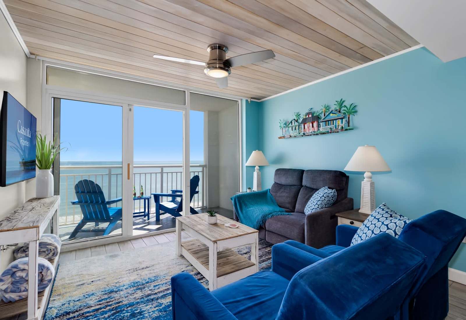Relax in this bright and inviting living room, featuring cozy seating, beachy decor, and a private balcony with stunning ocean views. Perfect for unwinding after a day of sun and sand.