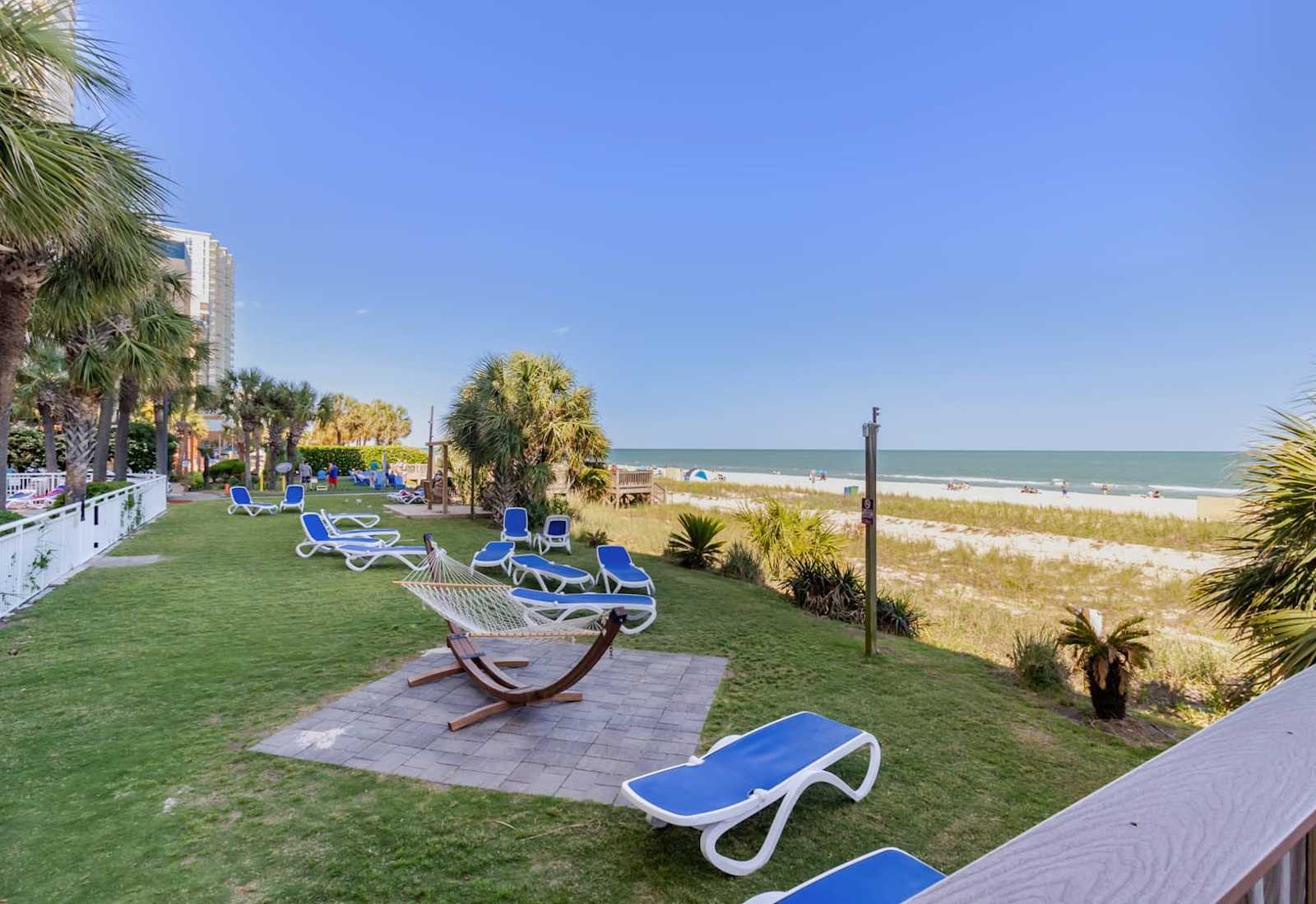 Relax in paradise with this beachfront oasis! Enjoy sun-soaked lounge chairs, a cozy hammock, and direct access to the sandy shores. Perfect for unwinding or catching the ocean breeze.