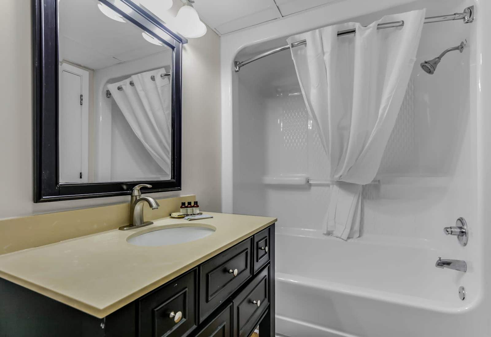 Experience comfort and convenience in this clean, modern bathroom. Featuring a spacious vanity, elegant mirror, and shower/tub combo, it’s the perfect space to refresh after a day at the beach!