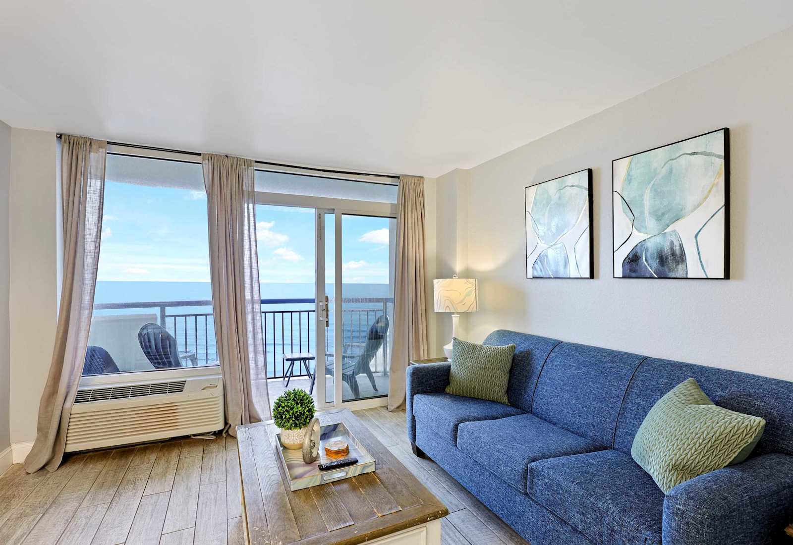 Soak up stunning ocean views from this cozy and stylish living space featuring a comfy sofa, chic decor, and direct access to your private beachfront balcony—perfect for your relaxing Myrtle Beach escape!