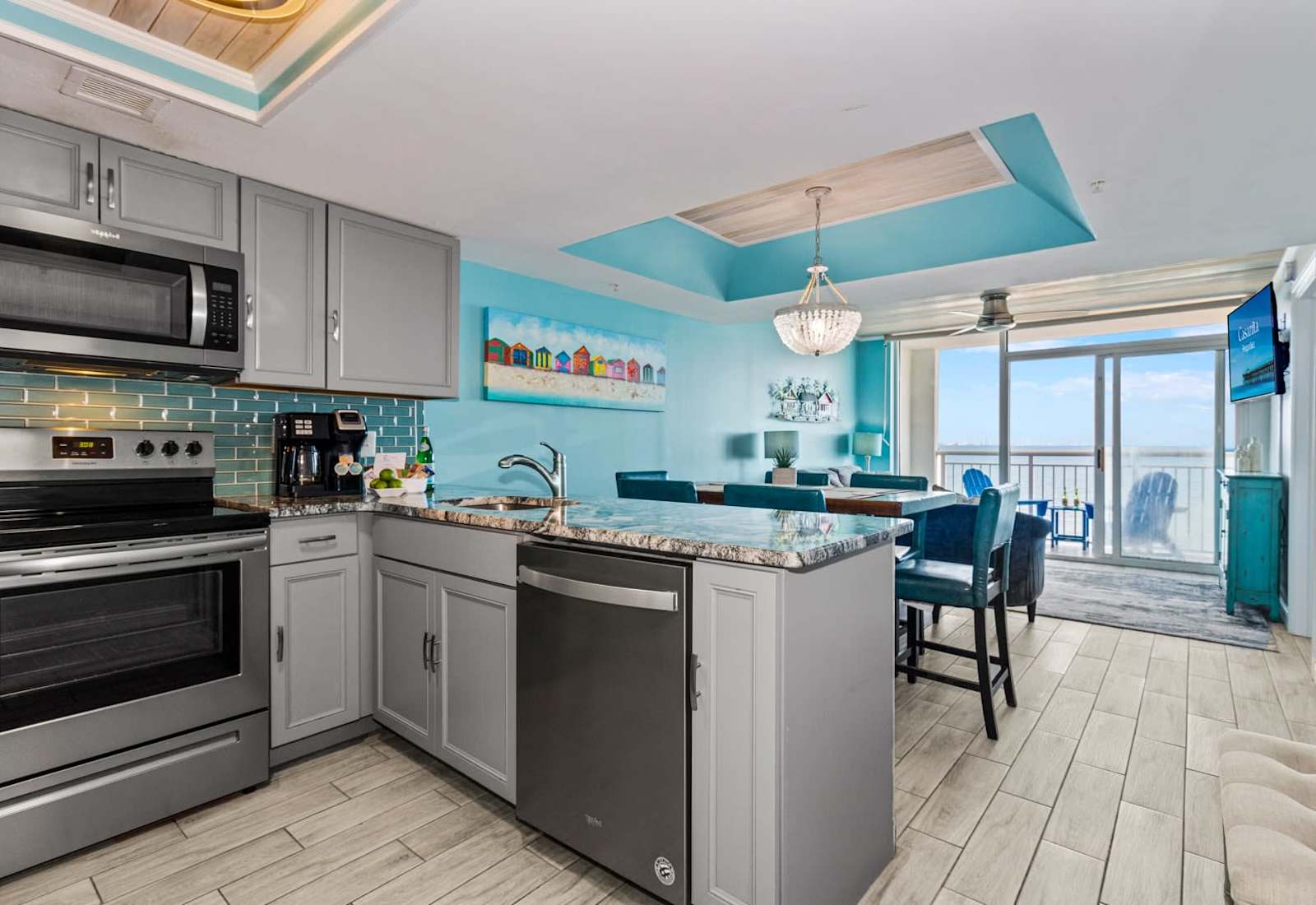 Cook, dine, and relax in this stunning open-concept space featuring a modern kitchen with granite countertops, stainless steel appliances, and vibrant coastal accents. The dining area flows seamlessly to the living room, all with gorgeous ocean views