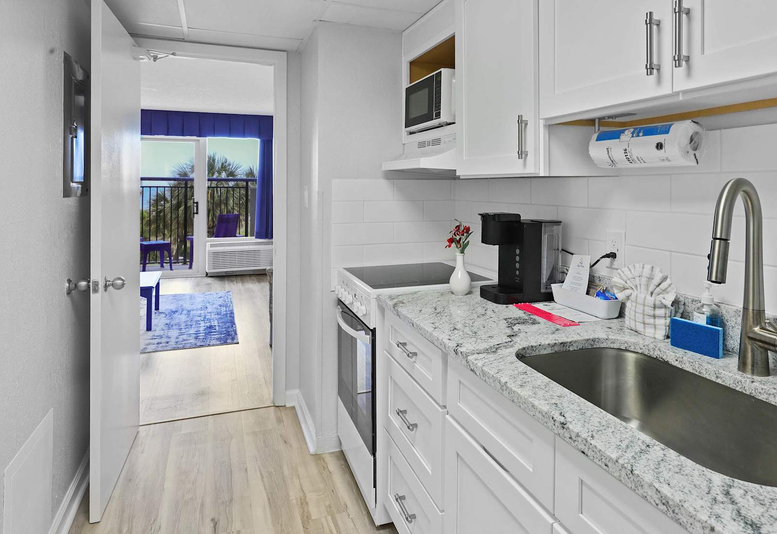 Whip up breakfast with an ocean breeze just steps away! This sleek, fully stocked kitchen has everything you need—and the view from the doorway? Just icing on the cake. 