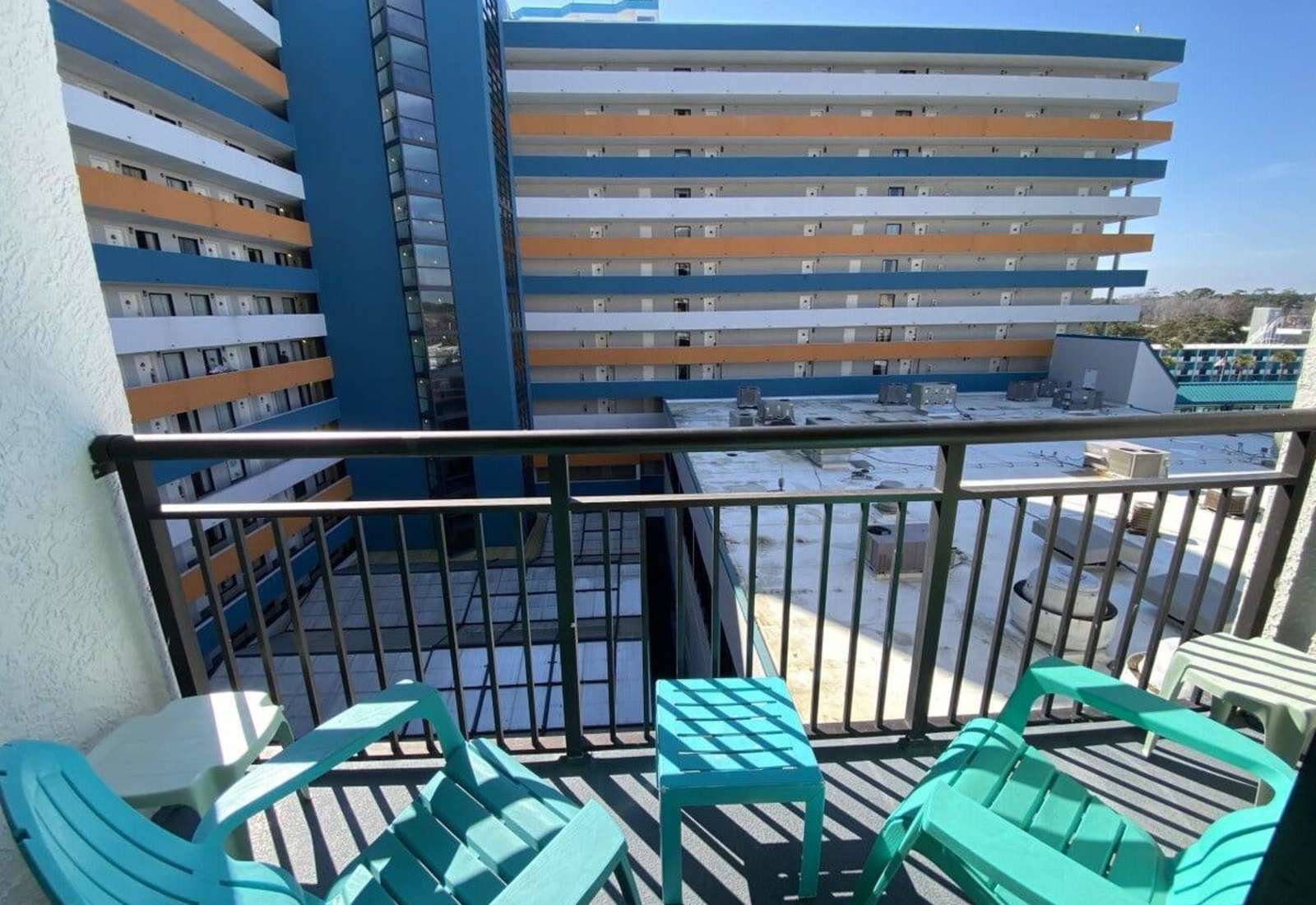 Private balcony featuring colorful Adirondack chairs and a small table overlooking the resort complex