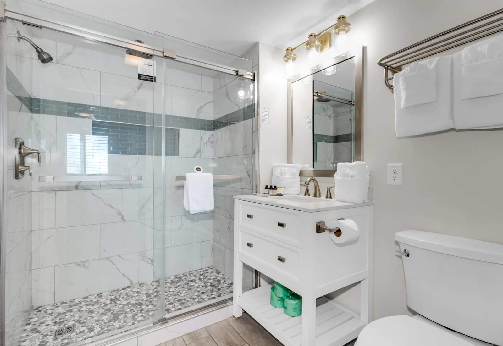 Refresh in this elegant bathroom featuring a walk-in glass shower with sleek tile accents, modern fixtures, and soft lighting. Complete with plush towels and luxury toiletries, it’s the perfect place to unwind after a day at the beach.