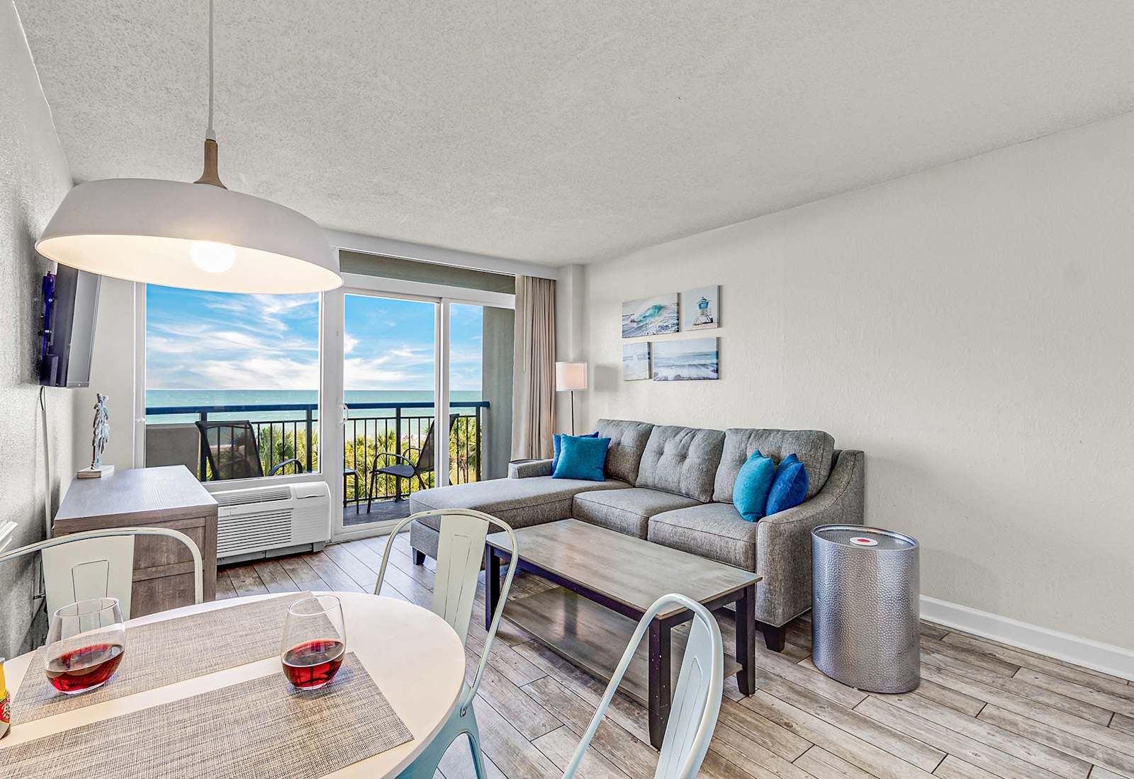 Relax with breathtaking ocean views from this bright, open living space—featuring a cozy sectional, beach-inspired décor, and a private balcony perfect for morning coffee or sunset wine by the sea.