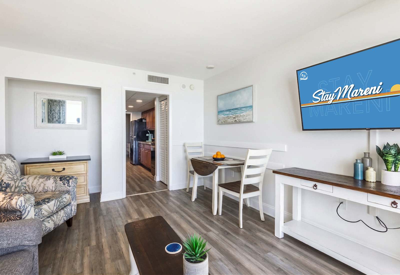 Experience coastal comfort in this bright and inviting living space! Relax in the stylish seating area, enjoy meals at the cozy dining nook, and stay entertained with a large flat-screen TV. The perfect setting for your beachside getaway!