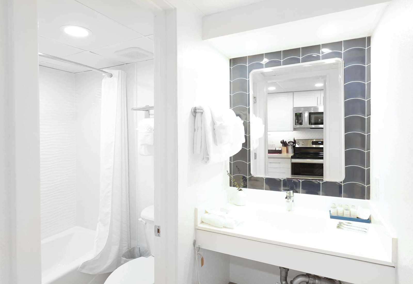 Unwind in this tranquil bathroom, featuring a spacious bathtub, plush towels, and a calming white and blue color scheme. Perfect for a relaxing soak after a day of adventure.
