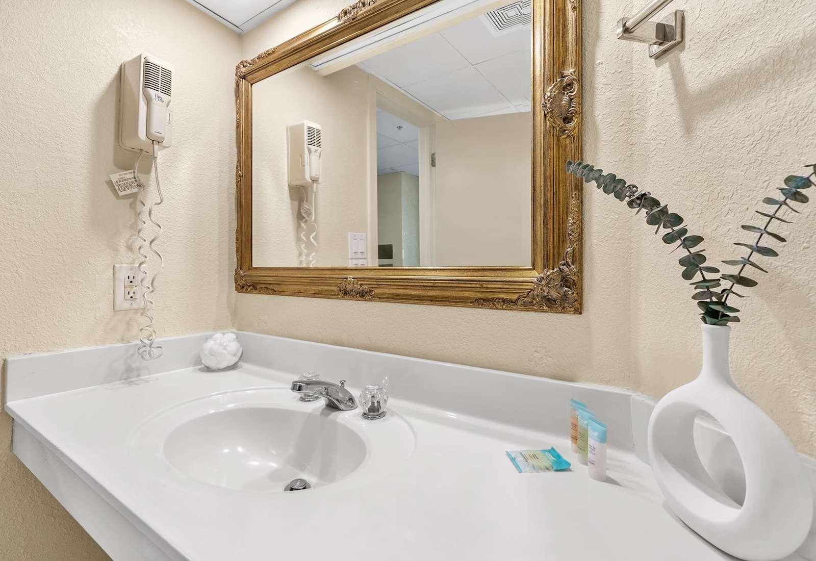 Get ready for your day in our classic bathroom, featuring a spacious vanity, a large mirror, and a touch of elegance. 
