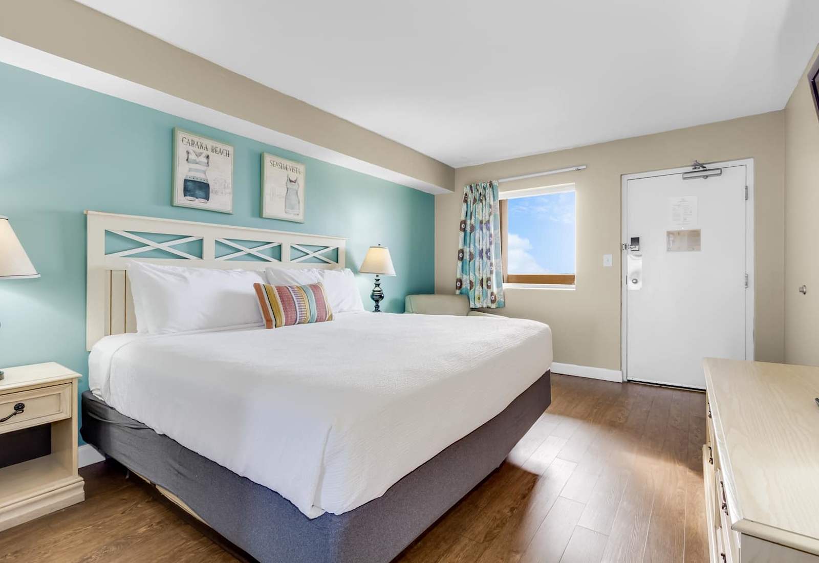 Bright and inviting bedroom featuring a plush king-size bed, soothing coastal colors, and natural light streaming through the window. A perfect retreat for a restful and rejuvenating stay!