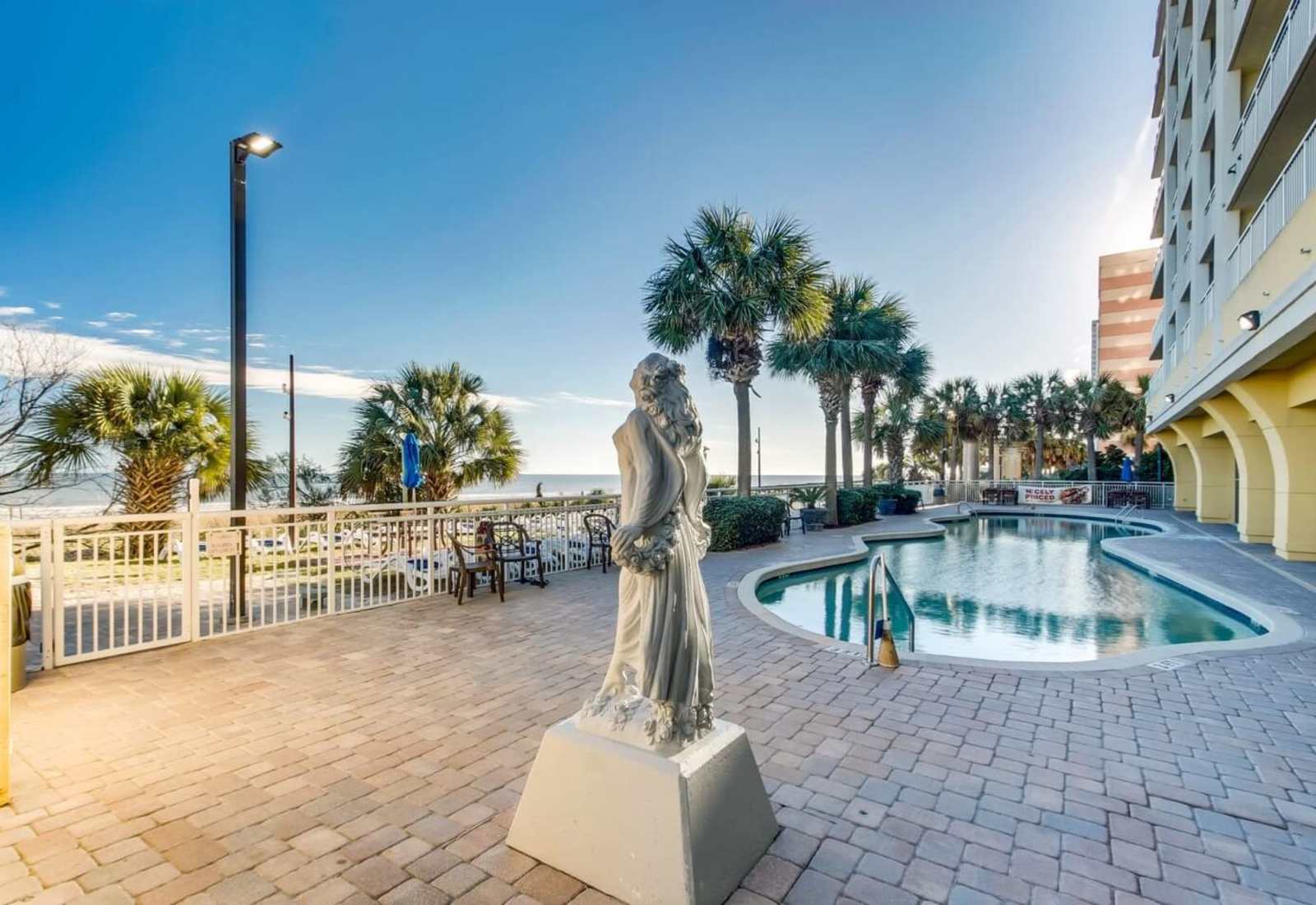 Relax by the pool with stunning ocean views and a serene atmosphere, complemented by beautiful sculptures and palm-lined paths. Enjoy the peaceful surroundings and easy access to beach fun, making your stay truly memorable.