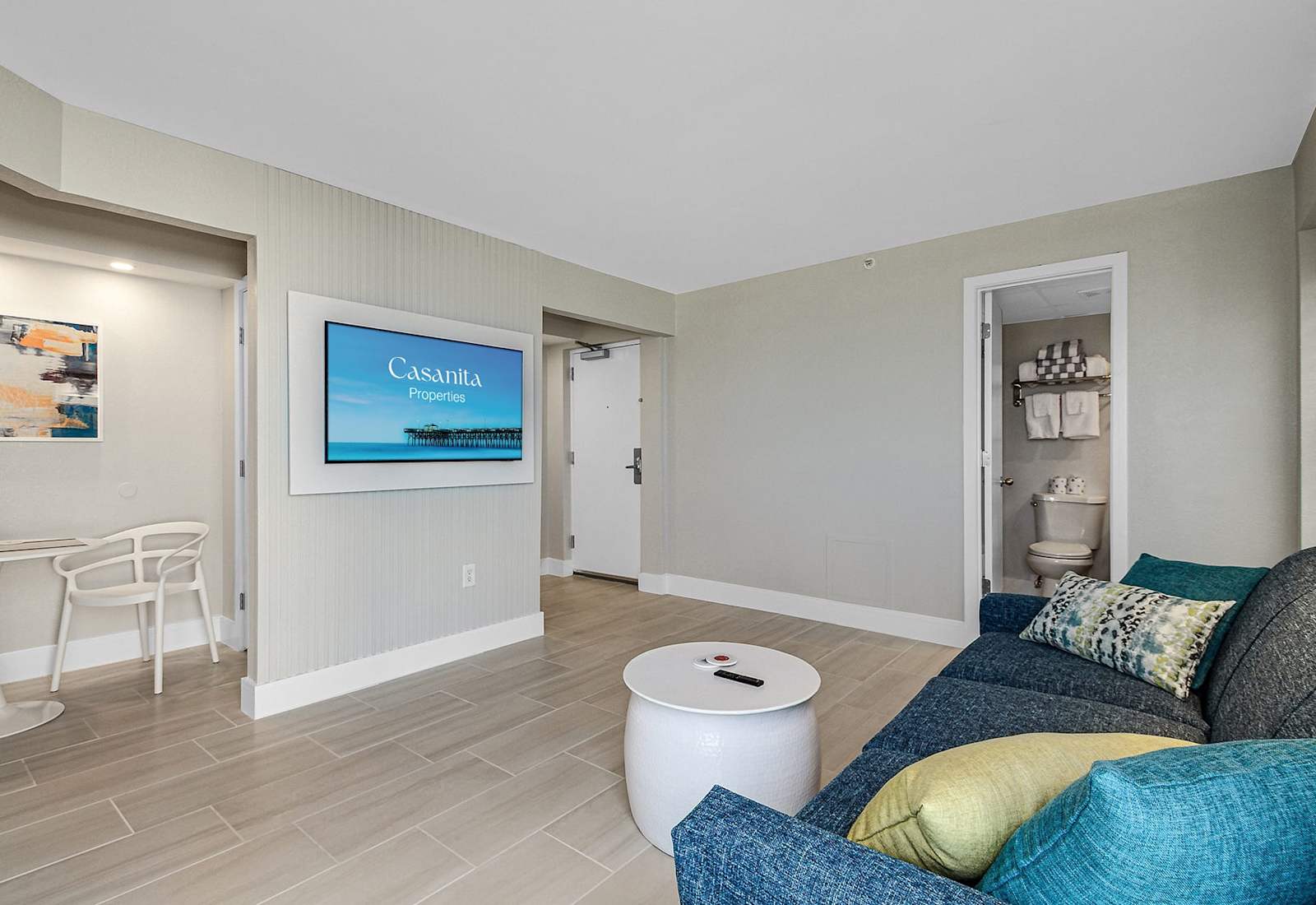 
Relax in this inviting living space featuring a plush sectional sofa, wall-mounted TV, and modern decor. Perfect for unwinding after a day at the beach, this cozy area offers comfort and style, with easy access to the kitchen and bedroom.