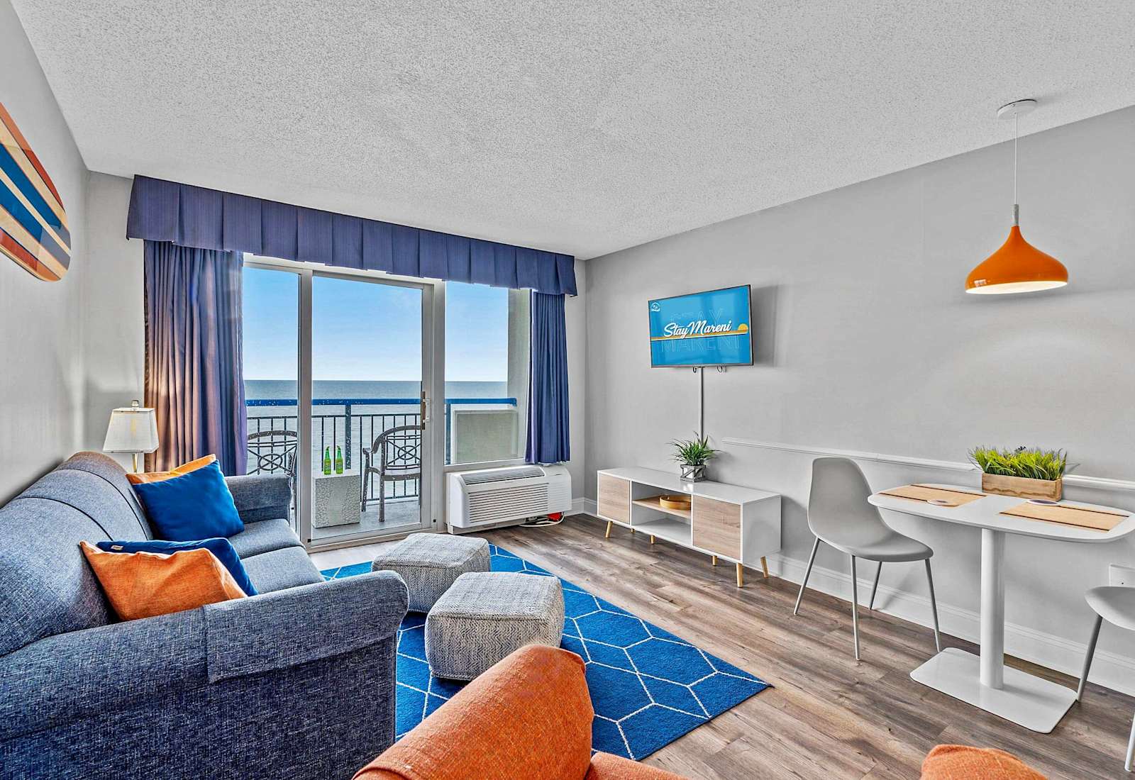 Relax and unwind in the spacious living room with comfortable seating, a large flat-screen TV, and stunning ocean views. 
