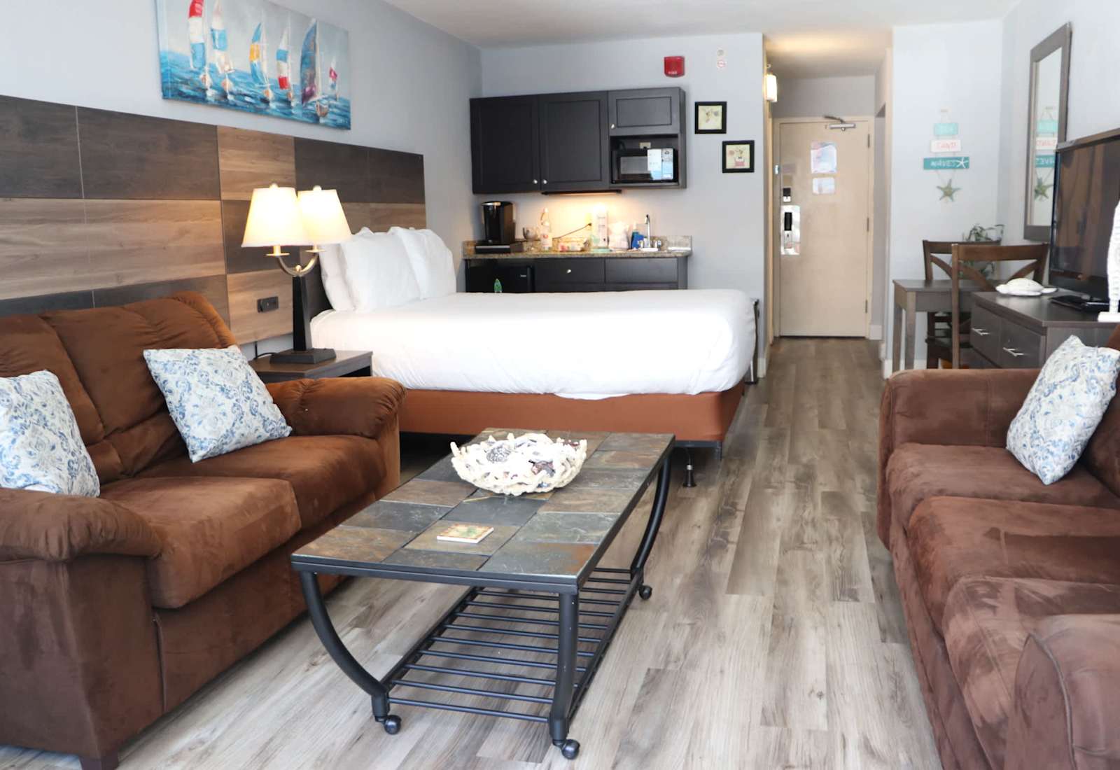 Spacious studio-style retreat with cozy seating, a comfortable bed, kitchenette, dining area, and beach-inspired décor — everything you need for a relaxing Myrtle Beach getaway.