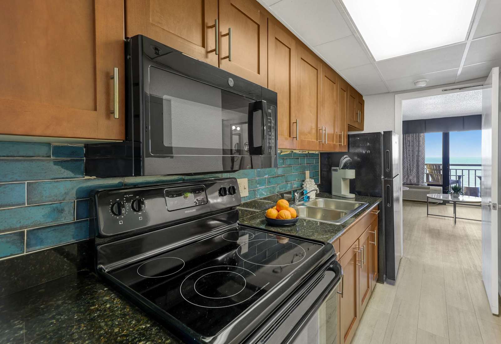 Cook with a view in this fully equipped kitchen featuring granite countertops, modern appliances, and a stylish backsplash. Whether it's breakfast or a beach day snack, everything you need is just steps from the ocean.