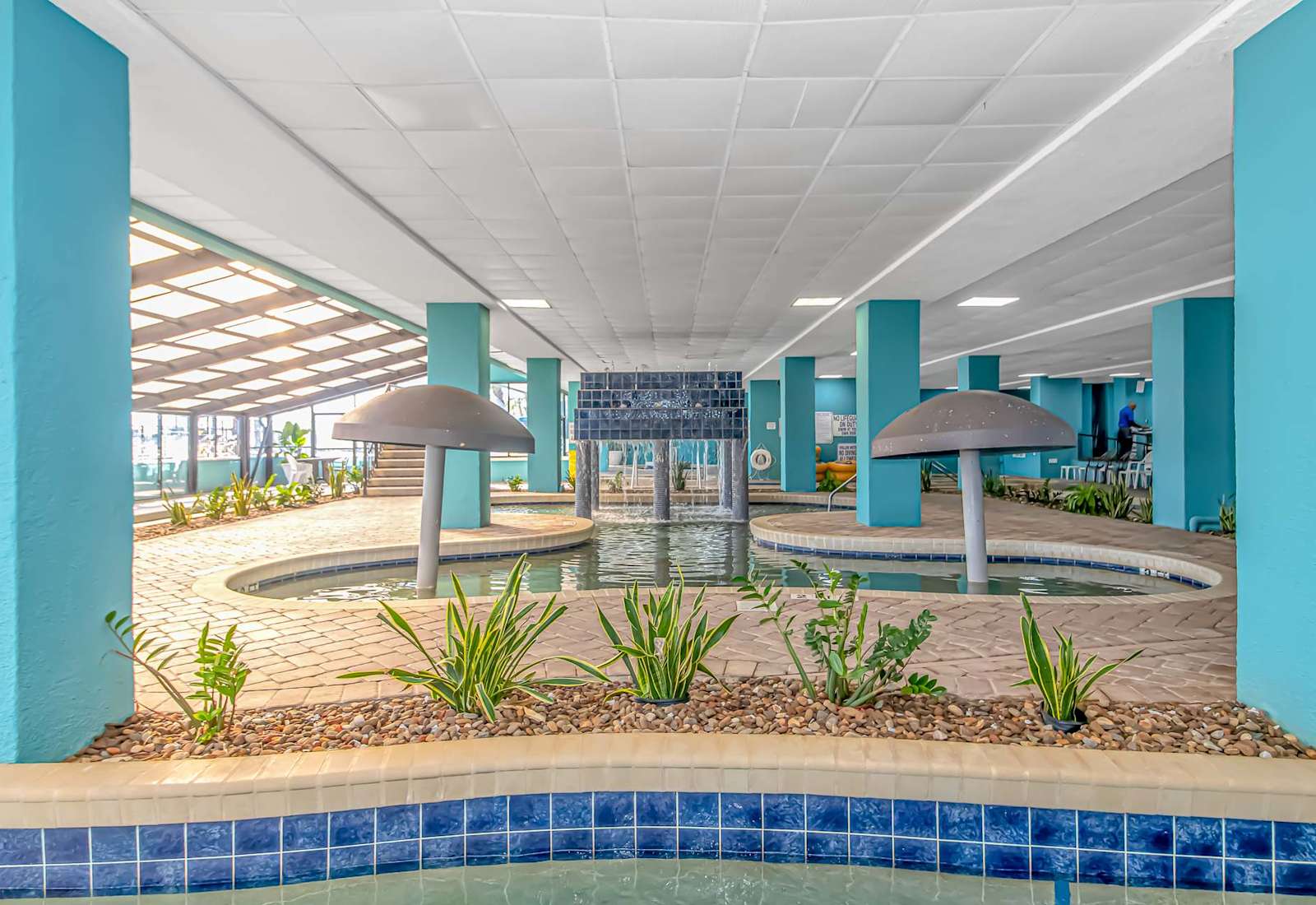 Indoor water feature area with shallow pools, fountain accents, and shaded seating for a fun, relaxing break during your Myrtle Beach stay.