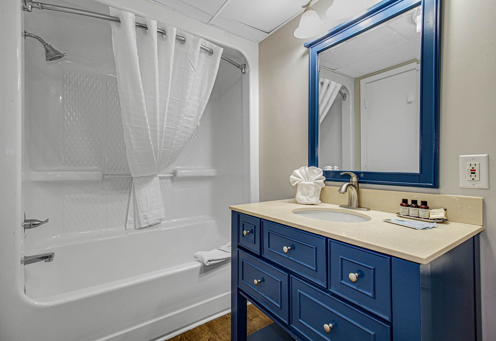 Freshen up in this bright and modern bathroom featuring a sparkling clean tub and shower, plush towels, and elegant vanity. Perfectly appointed for a refreshing start to your day or a relaxing evening soak after a day by the beach.