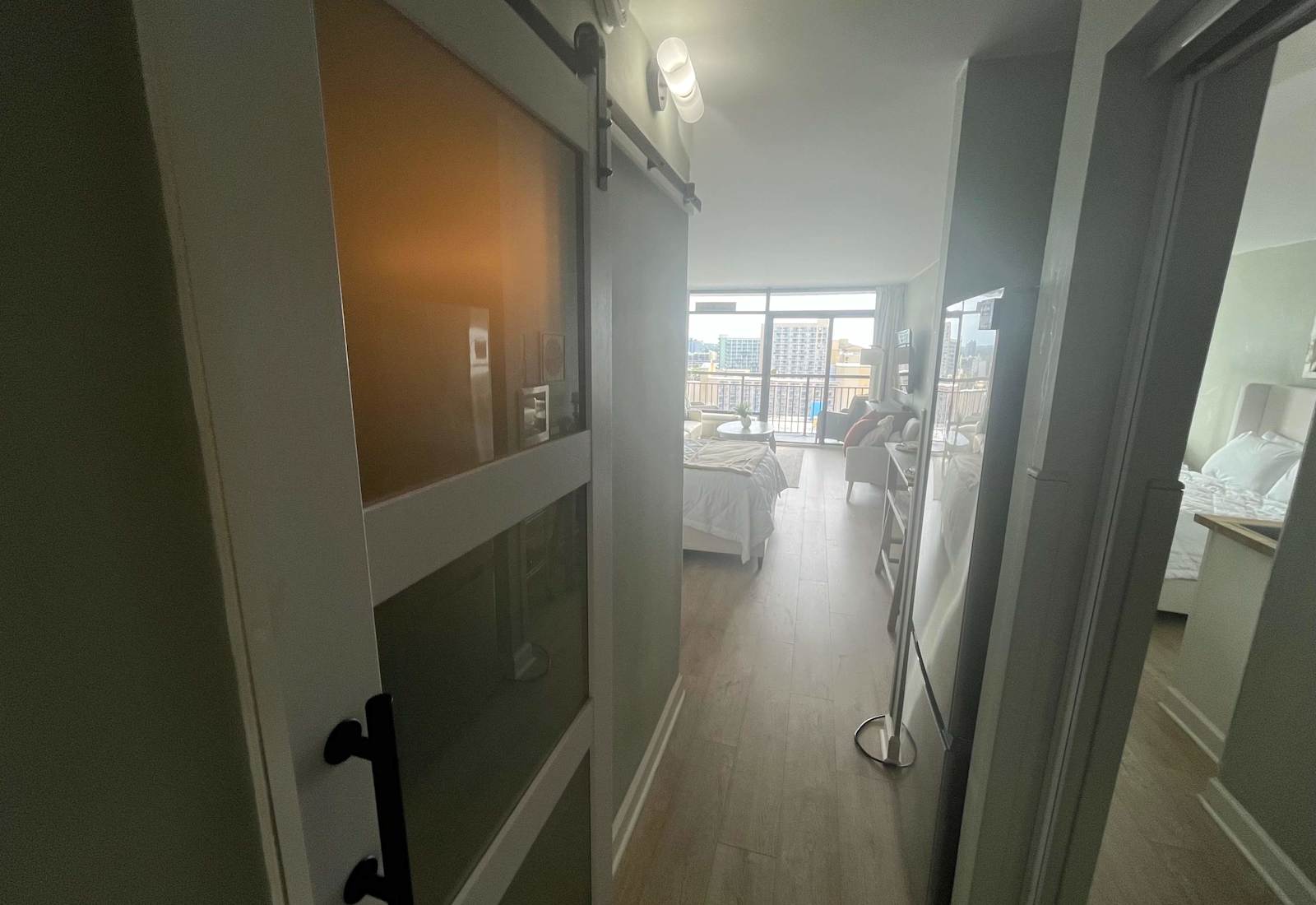 Welcoming entryway featuring a modern frosted-glass barn door that opens up to the main studio living space