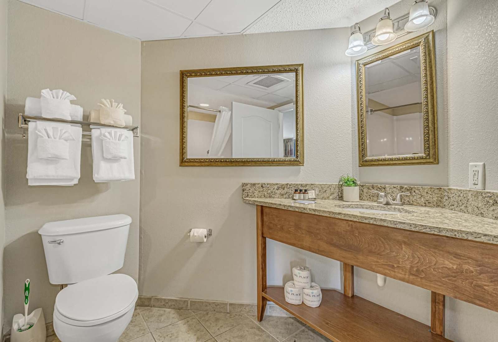 Clean bathroom with a spacious granite vanity, fresh folded towels, and stocked essentials for a comfortable beach stay.
