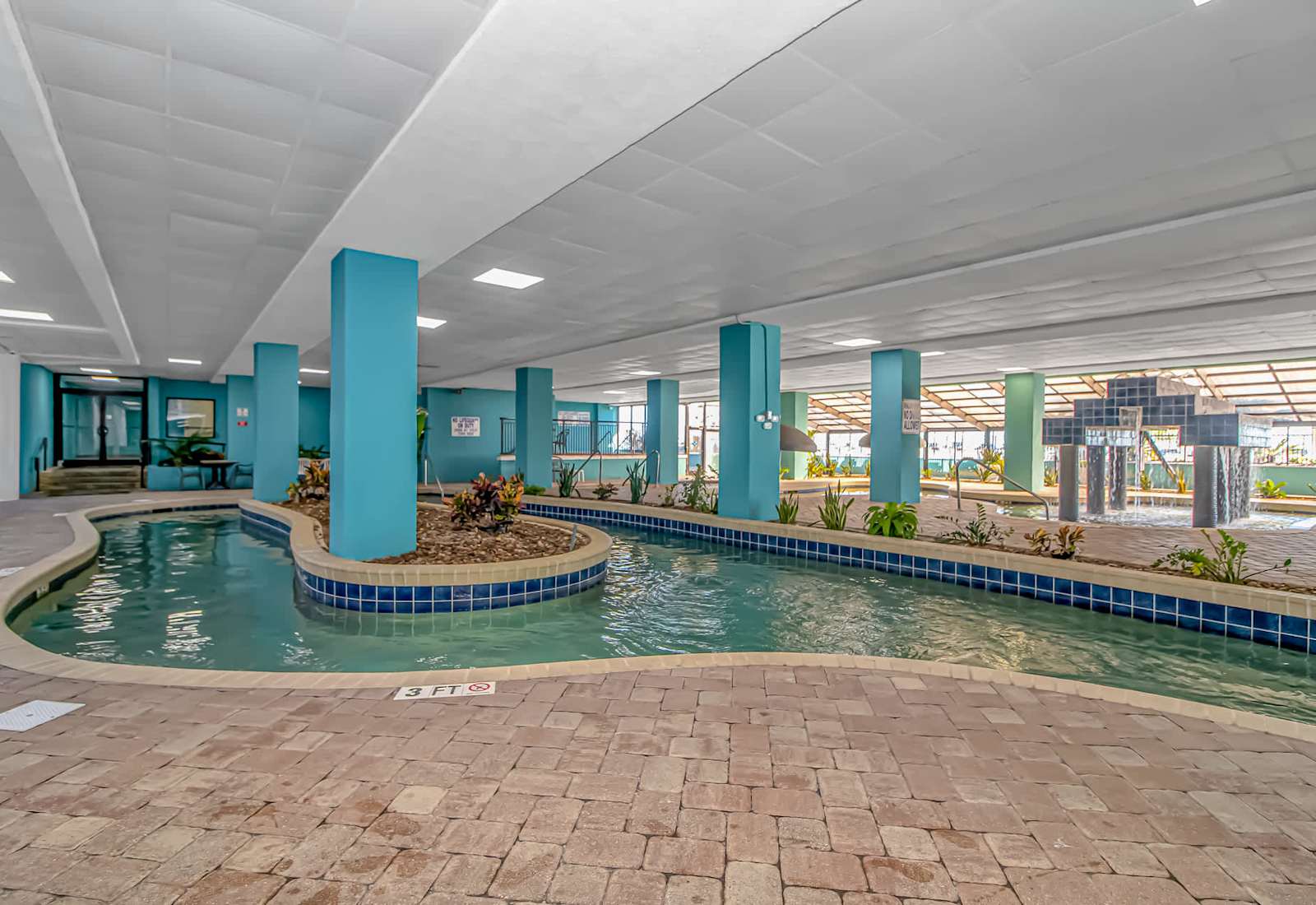 Spacious covered pool area with seating and a fountain feature, perfect for a refreshing swim away from the midday sun.