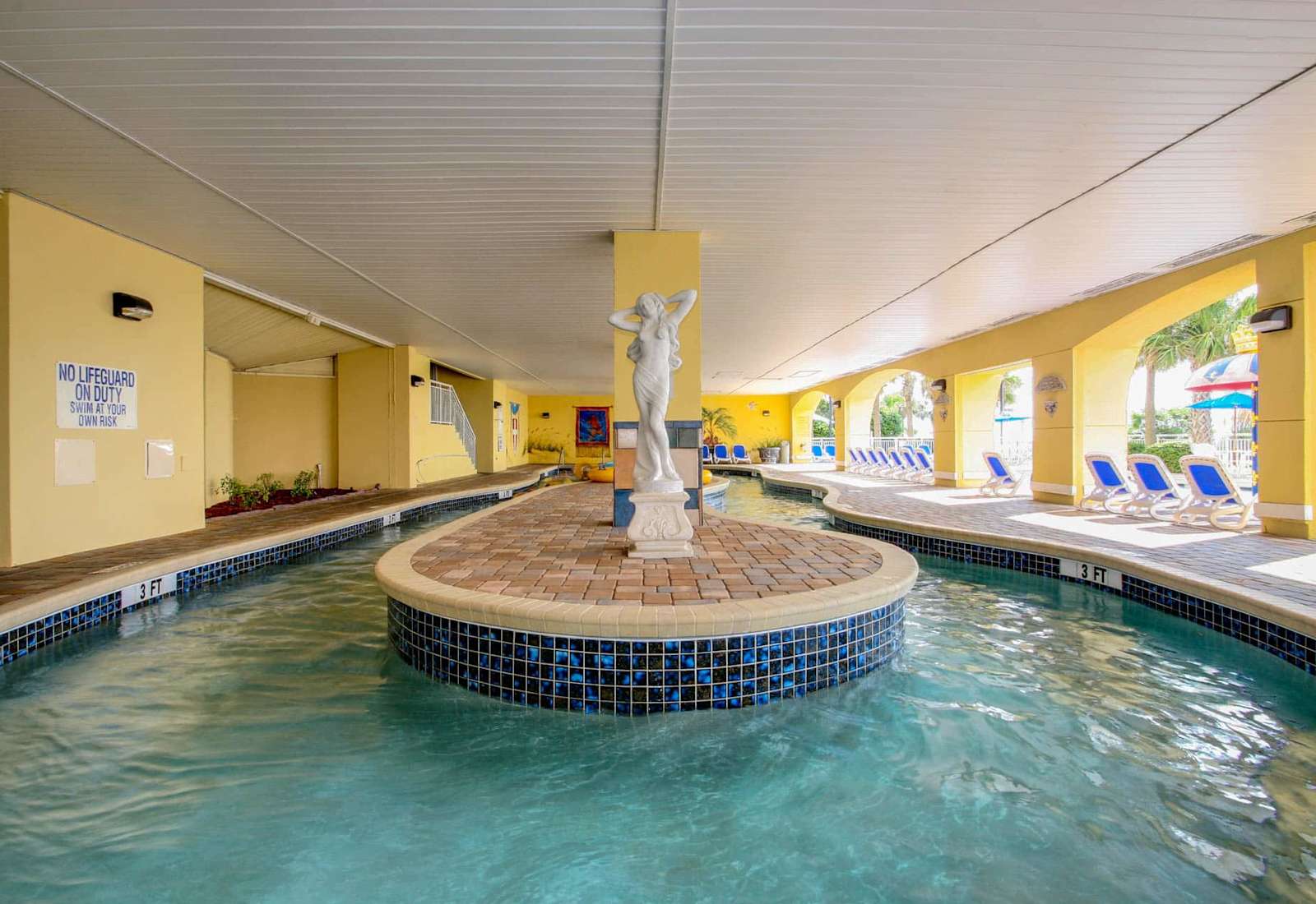 Unwind in this charming indoor pool area, featuring a serene statue centerpiece and a relaxing atmosphere. Perfect for a peaceful swim or lounging in the sun. Enjoy comfort and style—book your stay today for a memorable getaway!
