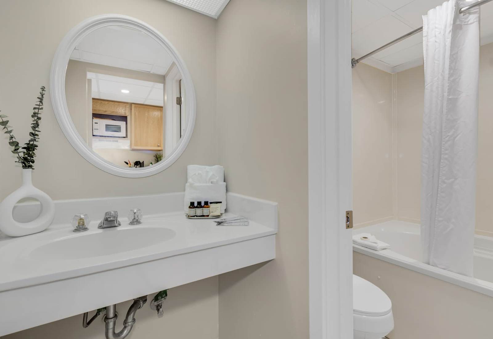 Bright and spotless bathroom featuring a full tub, soft towels, and modern lighting—perfect for a refreshing rinse after the beach or a relaxing soak to unwind at the end of the day.