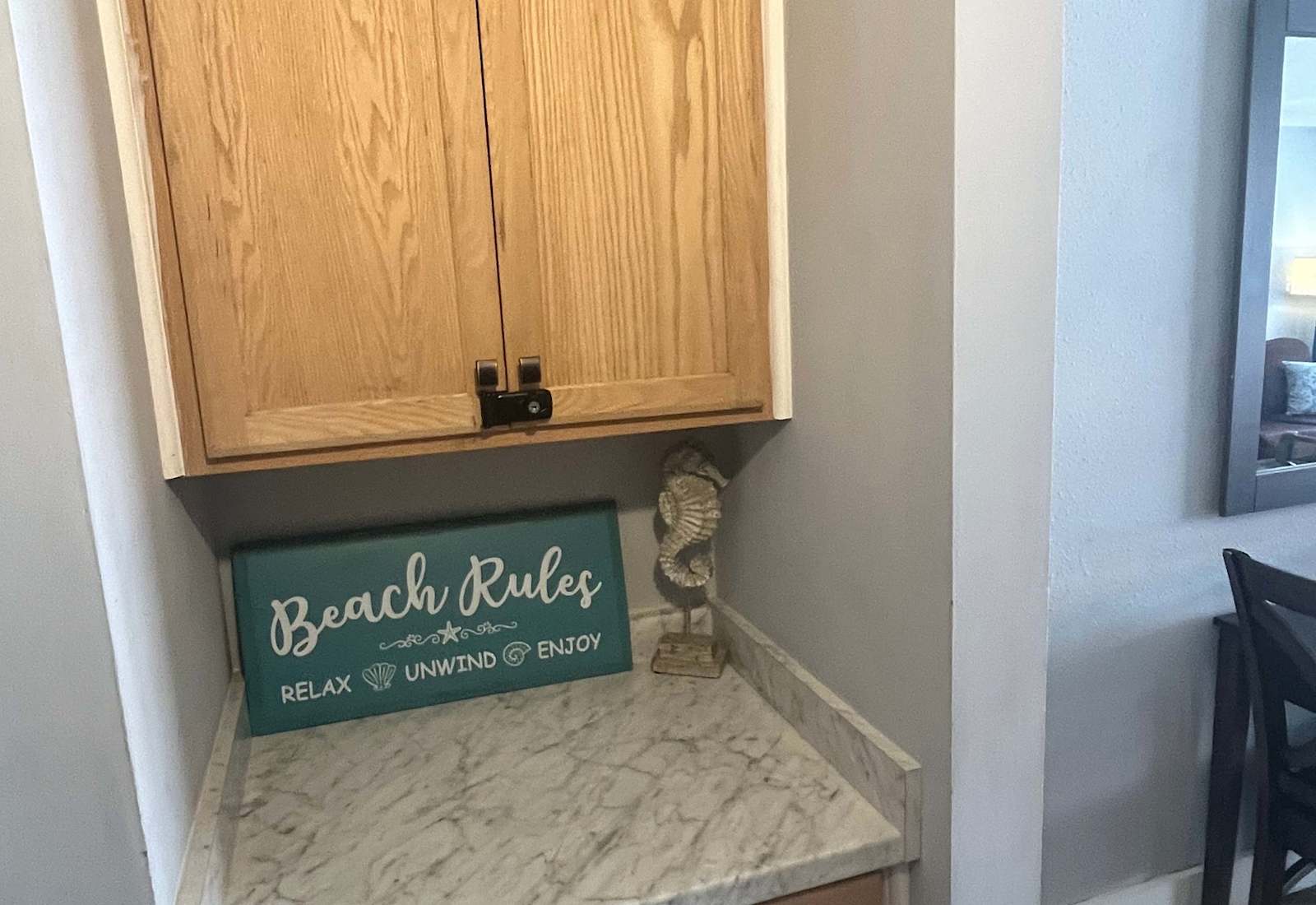 Small storage nook featuring light wood cabinetry, a laminate countertop