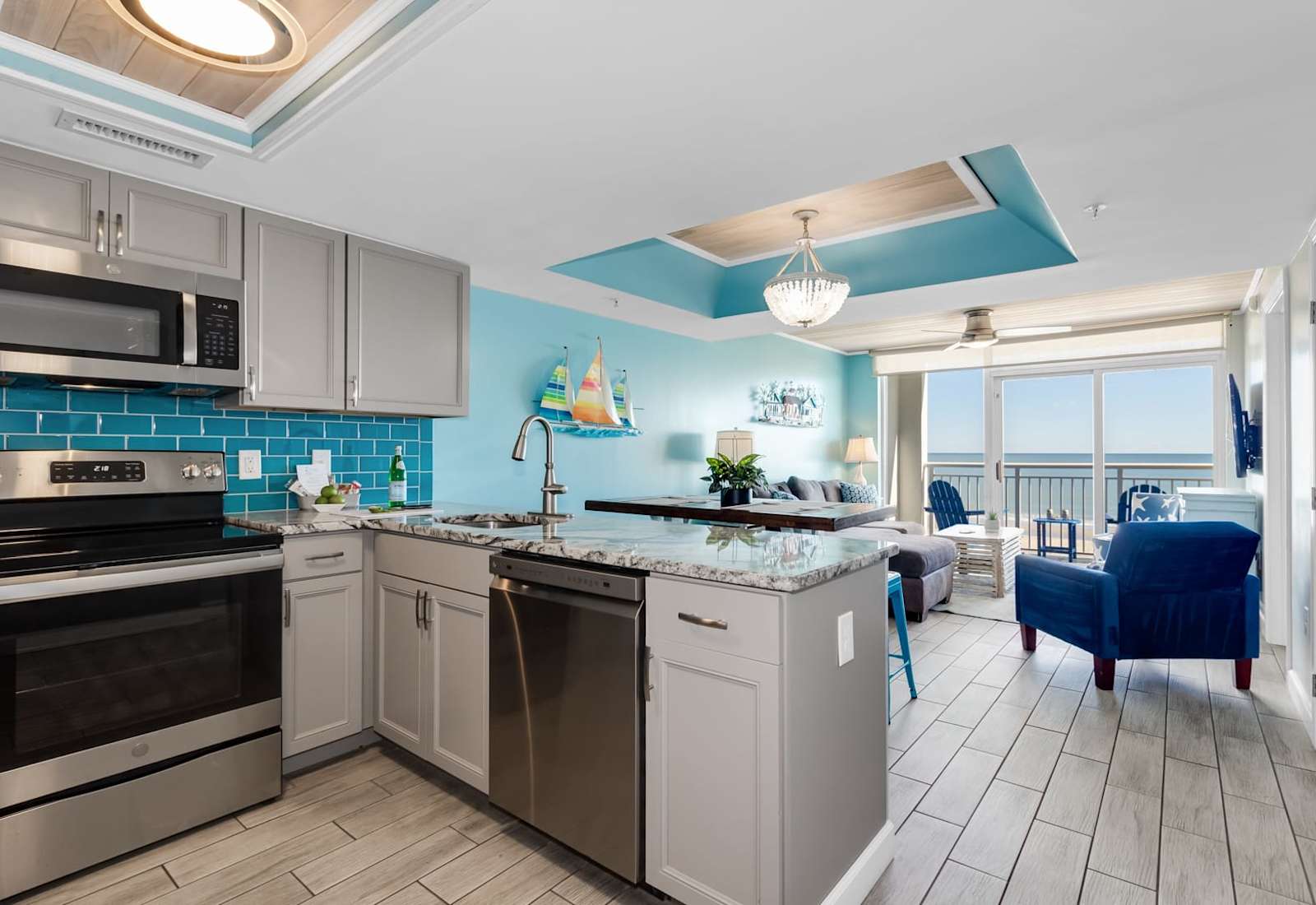 Whip up your favorite meals in this beautifully designed kitchen, featuring modern appliances, stunning blue accents, and granite countertops. Whether cooking or relaxing in the cozy living area with ocean views, this space offers the perfect blend.