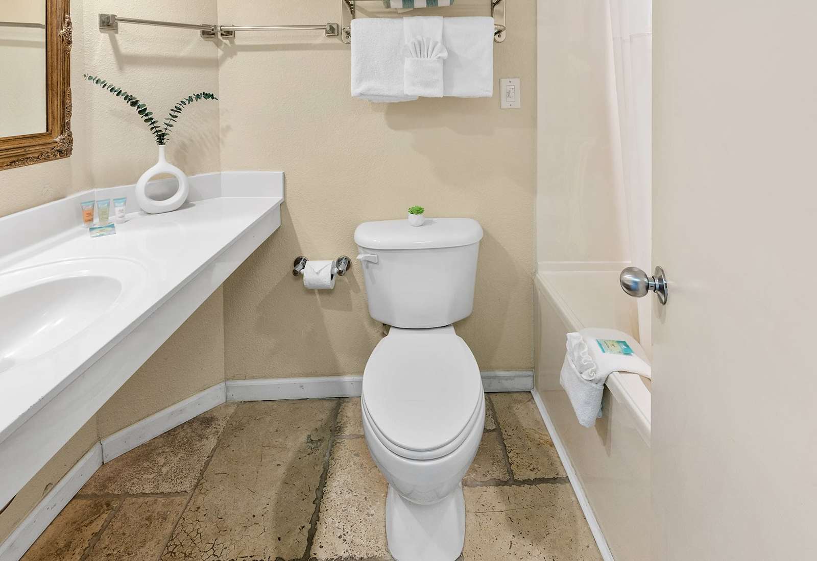 Freshen up in our spacious bathroom, featuring a double vanity, a comfortable toilet, and a clean and inviting atmosphere. 
