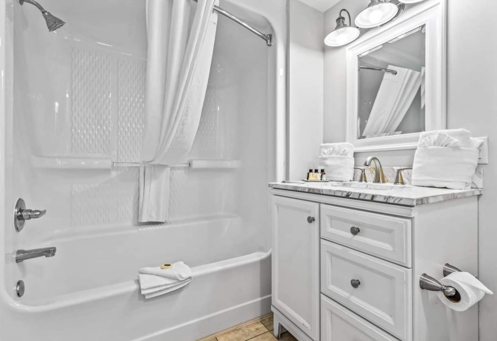 Refresh in this elegant bathroom featuring a walk-in glass shower with sleek tile accents, modern fixtures, and soft lighting. Complete with plush towels and luxury toiletries, it’s the perfect place to unwind after a day at the beach.