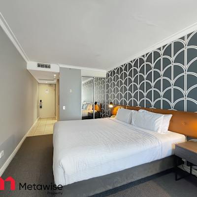 Spacious and modern bedroom with a comfortable king-sized bed and stylish decor.