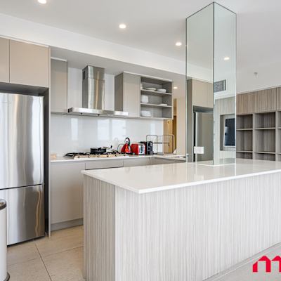 Kitchen with island bench, refrigerator, and open-plan layout.