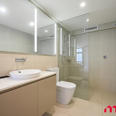 Bathroom with vanity, mirror cabinet, shower, and toilet.