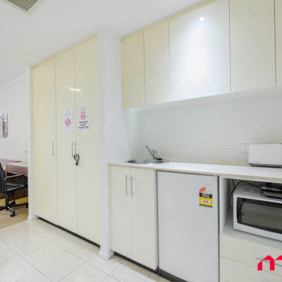 Kitchenette area featuring built-in cabinetry, bar fridge, microwave, kettle, and toaster.