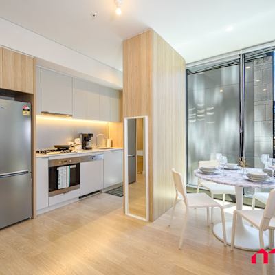 Modern kitchen with fridge, oven, cooktop, and cabinetry.
