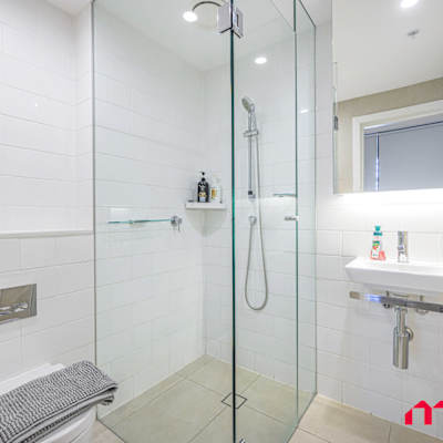 Bathroom with walk-in shower, toilet, and vanity.