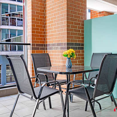Private balcony with outdoor table and chairs.