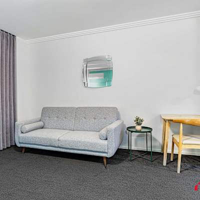 Additional angle of the sofa bed with small desk and wall décor.