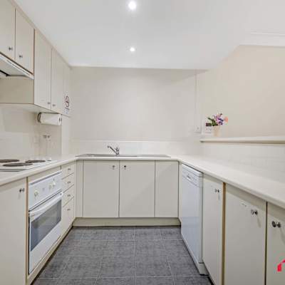 Fully equipped kitchen with ample cabinetry, cooktop, oven, and preparation space.