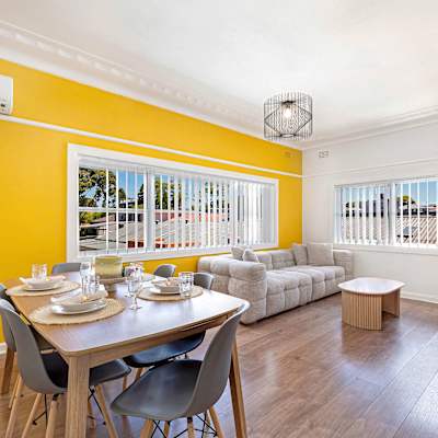 Dining area adjacent to living space with table setting and split system air-conditioning.