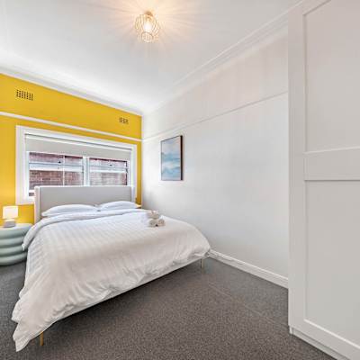 Bedroom 2 featuring a queen-size bed, built-in wardrobe, and neutral styling.