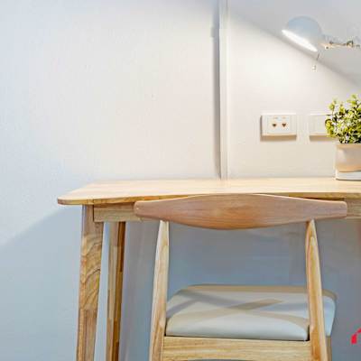 Compact wooden work desk with lamp and decorative plant.