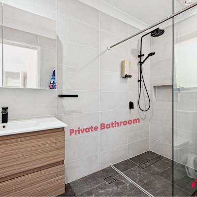 Modern bathroom with vanity, toilet, and glass-enclosed shower.