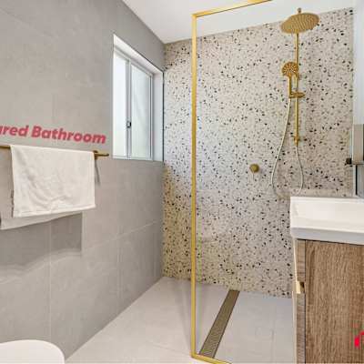 Shared bathroom with modern vanity, toilet, and glass shower enclosure.