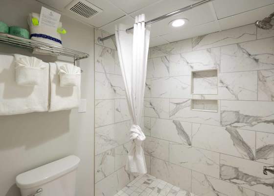 Start your day in this sleek, spa-inspired walk-in shower—where marble vibes meet beachside calm. Plush towels, built-in shelving, and modern touches make this bathroom feel like a mini retreat. 