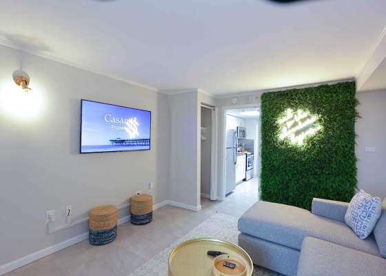 Binge your favorite shows, sip something chilled, and snap a selfie in front of the neon-lit moss wall—this living space is giving major vacation vibes with a side of style. 