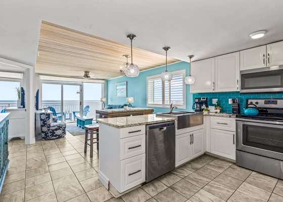 Cook, dine, and relax in this stunning open-concept space featuring a modern kitchen with granite countertops, stainless steel appliances, and vibrant coastal accents. The dining area flows seamlessly to the living room, all with gorgeous ocean views